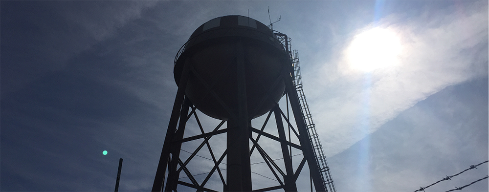 potable water storage tank with blue sky and sun