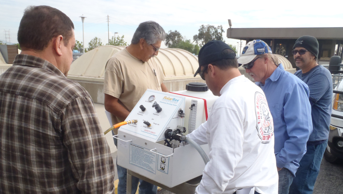 group of people training on a Medora Corporation disinfectant boost system for potable water storage tanks 