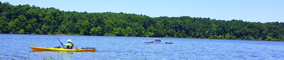 canoe passing by SolarBee during Jordan Lake SolarBee Demonstration Project