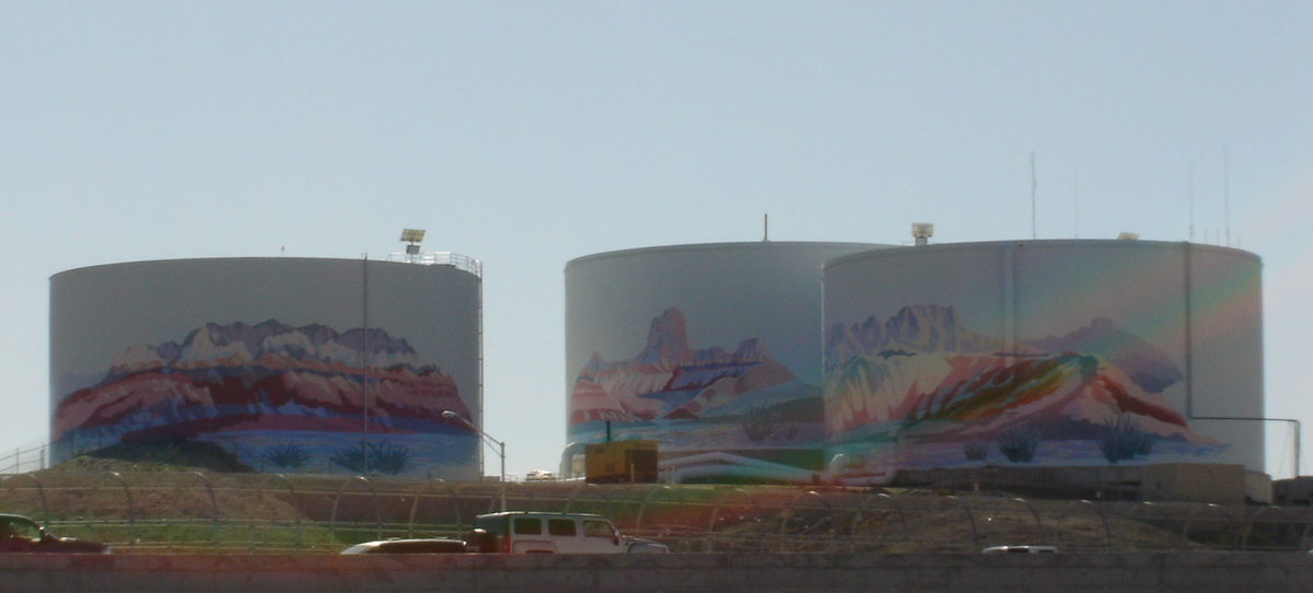 nicely painted water storage tanks in distance road traffic in foreground