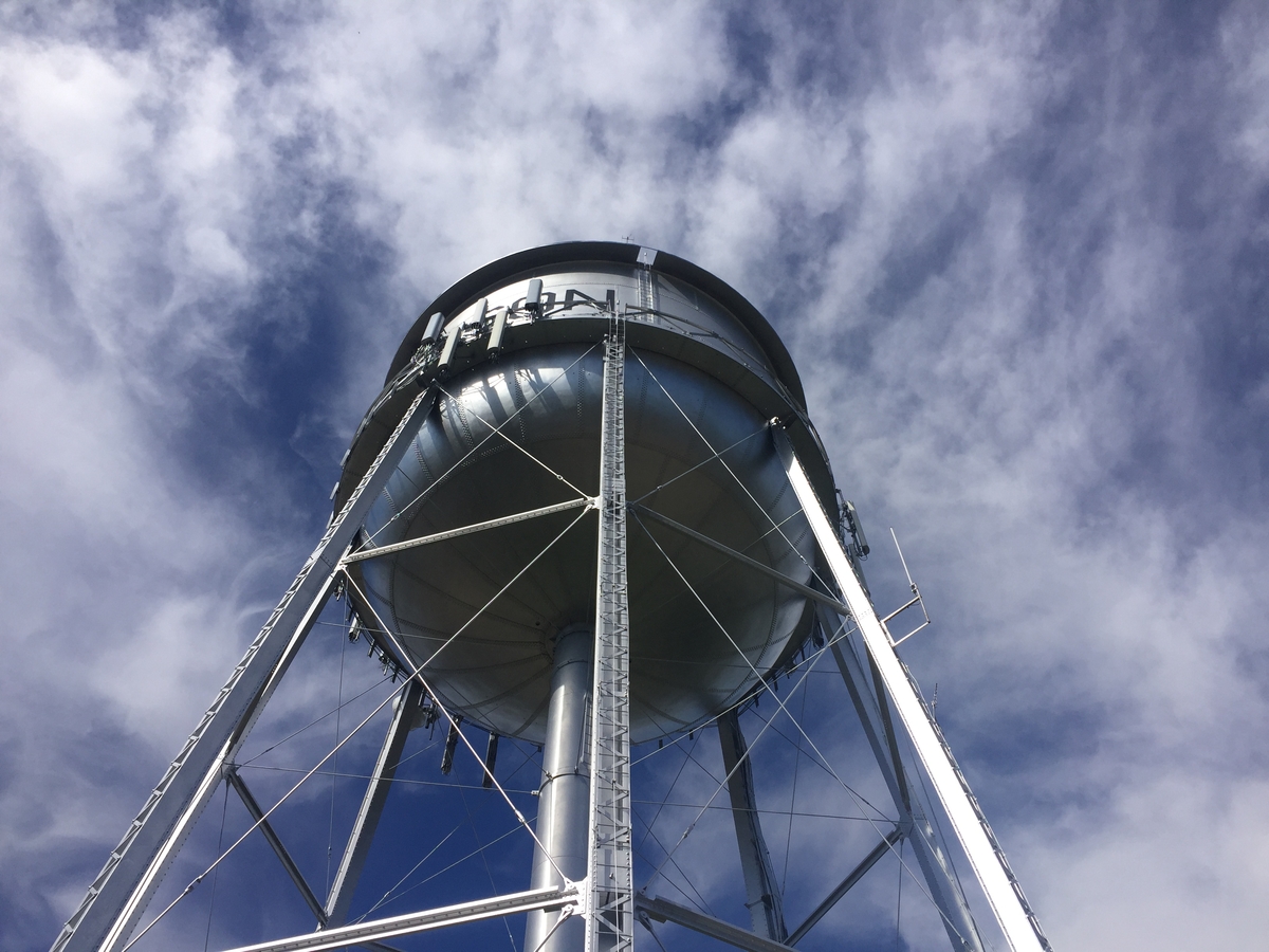 potable water storage tank with mixing against cloudy blue sky
