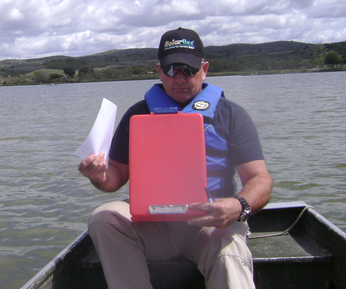 in a boat on a lake reviewing water quality test data